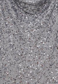 Tejido plateado con lentejuelas, que presenta una superficie texturizada, con lentejuelas de diferentes tamaños y un ligero brillo sobre un fondo gris claro.