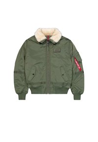 Veste bombardier verte avec col en shearling crème, fermeture éclair à l'avant, deux poches à rabat et une poche sur la manche avec une étiquette rouge.
