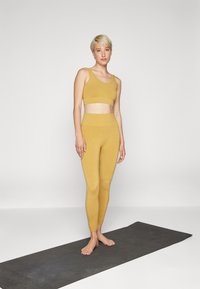Yogasearcher HADU - Sport-bh met light support - curry