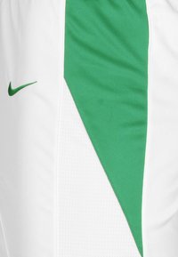 Weiße Shorts mit einem grünen schrägen Einsatz, hergestellt aus atmungsaktivem Material. Mit einem kleinen schwarzen Nike-Logo auf der linken Seite.