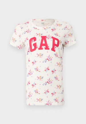 Valkoinen lyhythihainen T-paita, jossa värikäs kukkakuosi ja suuret punaiset "GAP"-kirjaimet rintakehän kohdalla.