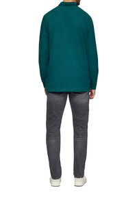 Taliowana, długorękawowa koszulka polo w kolorze teal z kołnierzykiem, w zestawie z szarymi dżinsami i jasnymi sneakersami, prezentująca prosty i elegancki wygląd.