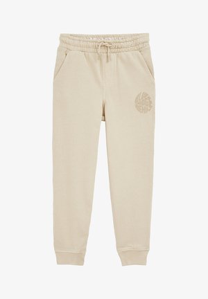 Beige joggingbukser i bomuld med elastik i taljen og snøre, sidelommer, opsmøgede ankler og rundt trykt logo på venstre lår.