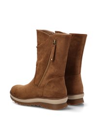 Botas de tobillo de ante marrón con un detalle de cremallera y superficie texturizada. Presenta una suela de goma con un color más claro en la base.