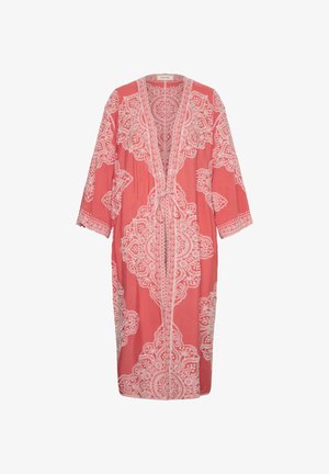 Coral pink long cardigan with white intricate lace-like patterns, open front, three-quarter sleeves, and a tie closure at the waist.