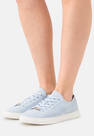 Baskets bleu clair avec une tige en mesh, bout rond, semelle blanche et lacets. Présentent un accent métallique sur la languette.