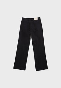Jean en denim noir vu de dos avec une coupe droite à jambes larges et deux poches arrière sur un fond uni clair.