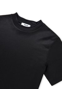 Camiseta de algodón negra, de manga corta, con cuello redondo y ribeteado. Cuenta con una etiqueta con "IPEKYOL" dentro del cuello.