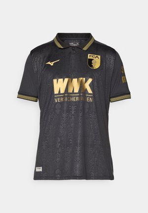 Schwarzes Sporttrikot mit goldenen Akzenten. Enthält ein strukturiertes Muster, einen Kragen und Logos für FCA und WWK. Kurzärmel mit gemusterten Bündchen.