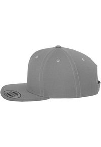 Grijze snapbackpet met een platte rand, gestructureerde kroon en zichtbare stiksels. De pet heeft zes oogjes voor ventilatie en een logosticker op de rand.