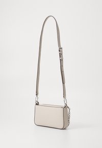 Beige läder crossover-väska med justerbar rem, silverfärgad hårdvara, rektangulär form och en texturerad yta. Har en kedjeaccent.