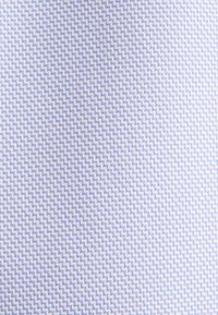 Tessuto blu chiaro caratterizzato da un motivo geometrico a zigzag in una trama testurizzata. Il design è ripetitivo e ben distribuito in tutto il tessuto.