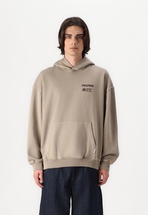 Haut à capuche marron clair en tissu doux, avec une poche avant, des poignets côtelés et une impression qui indique "PARIS" en bordeaux foncé.