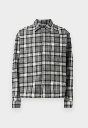 Chemise à carreaux noire et blanche avec col, manches longues et coupe décontractée. Fabriquée dans un tissu doux et texturé.