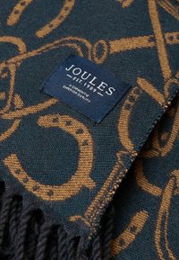 Tkáčska károvaná šatka v tmavomodrozelenom odtieni so zlatým vzorom s jazdeckou tematikou. Má strapcové okraje a štítok značky Joules.