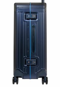 Marineblauwe harde koffer met verticale ribbels, een blauwe accentstrip, TSA-slot en twee wielen voor gemakkelijke verplaatsing.