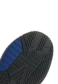 Suela de zapato de goma negra con un patrón de espiga texturizado. Presenta un área de acento azul con surcos horizontales para tracción.