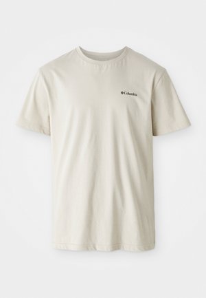 T-shirt en coton beige à manches courtes, col rond et petit logo noir sur la zone gauche de la poitrine. Tissu lisse et sans décoration.
