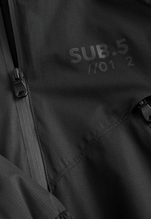 Schwarze, mit Reißverschluss versehene Jacke aus strukturiertem Stoff, mit dezentem Druck "SUB.5 //01 2" versehen. Verfügt über langlebige Reißverschlussbeschläge.