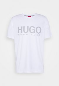 Hvid kortærmet T-shirt med stor grå "HUGO" tekst og mindre "HUGO BOSS" logo trykt nedenfor på fronten.