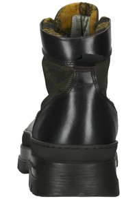 Stivaletto in pelle nera con lati in rete, parte superiore testurizzata e tallone rinforzato. Presenta una suola spessa e un tassello per una facile calzata.