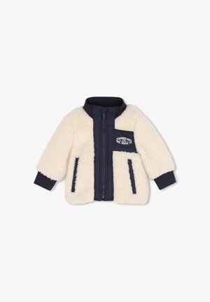 Roomkleurige sherpa-jas met marineblauwe rits, manchetten, kraag, twee zijzakken en een borstzak met Timberland-logo.