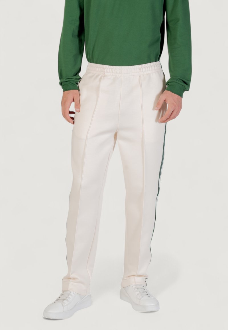 Sportliche Hosen in Creme mit strukturiertem Finish, elastischem Bund, seitlichen Streifen in Dunkelgrün und einem lockeren Schnitt.