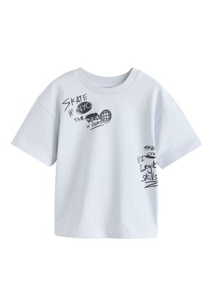 T-shirt blanc à manches courtes avec texte noir manuscrit et graphiques incluant "SKATE," "NYC," "THE WORLD IS OURS," et "Legit Skills."