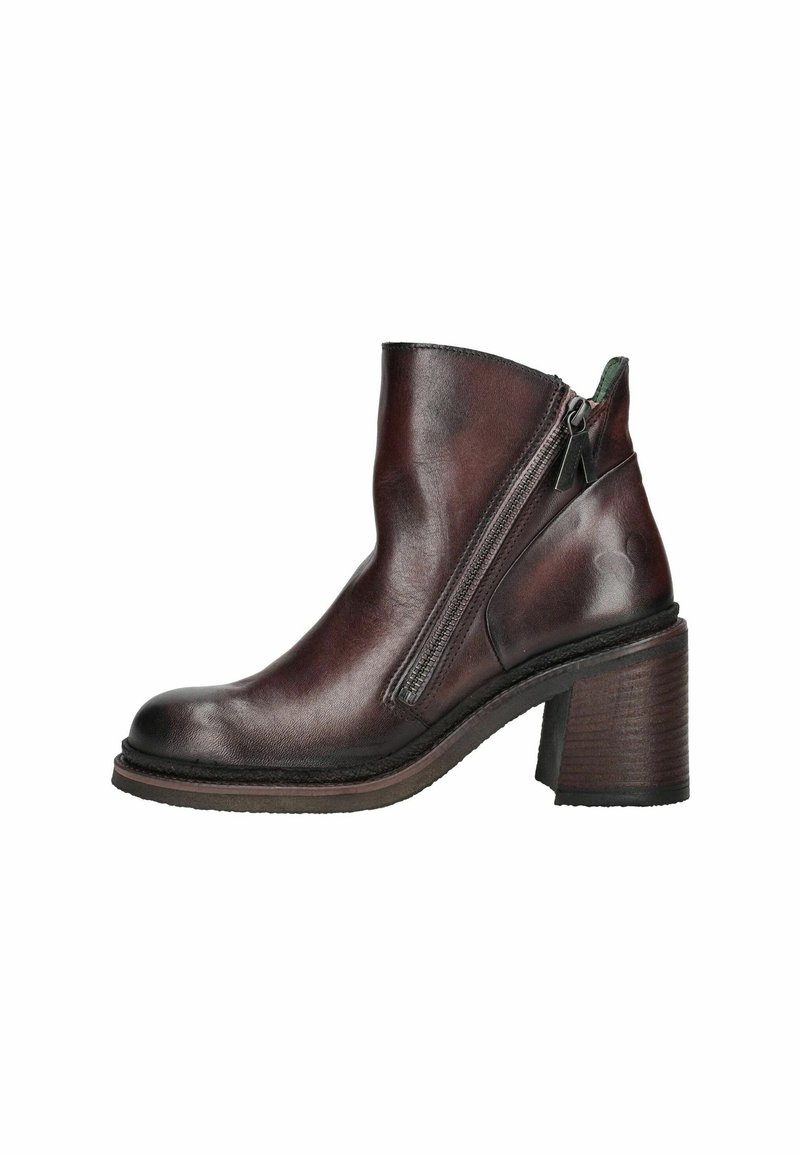 Bottine en cuir marron avec un talon épais, fermeture éclair sur le côté, texture lisse et bout arrondi. Elle présente des coutures discrètes et une semelle contrastante.