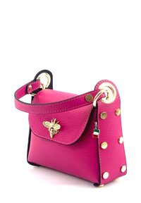 Kleine roze leren handtas met een bij-embleem, gouden hardware, zijknoppen en een zwarte schouderband. Heeft een flap sluiting en een compact formaat.