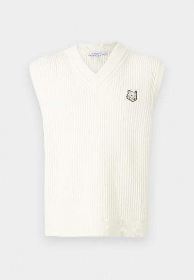 Valkoinen ribatut neulehihaton V-kauluksinen villapaita, jossa on pieni brodattu susipää vasemmassa rinnassa ja Maison Kitsuné -labeli kauluksessa.