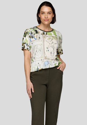 Short-sleeve shirt with a leafy green and patterned design. It features a crew neck and a relaxed fit, paired with olive-green trousers.