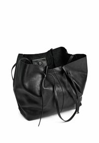 Borsa a secchiello nera in pelle con texture morbida, forma arrotondata, chiusura con coulisse e design minimalista. Nessun elemento hardware visibile.