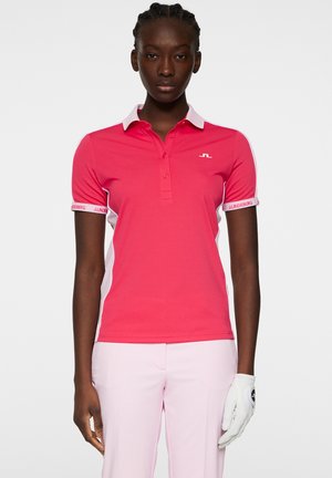 Polo shirt rosa aderente con collo classico, accenti bianchi sui lati e logo sul petto e sulle maniche. Materiale liscio e leggero.