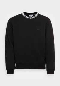 Zwarte sweatshirt met een geribde kraag, voorzien van een wit "LACOSTE" logo. Gemaakt van zachte stof, met lange mouwen en een reguliere pasvorm.