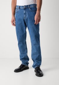 Světle modré džíny z denimového materiálu se rovnými nohavicemi, klasickým pět pocket stylem a kovovou knoflíkovou zapínací na pásu.