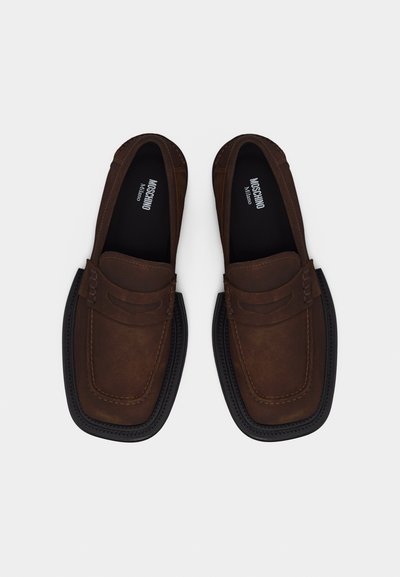 Paire de mocassins en cuir marron avec semelles larges noires et détails cousus, marqués Moschino Milano à l'intérieur.