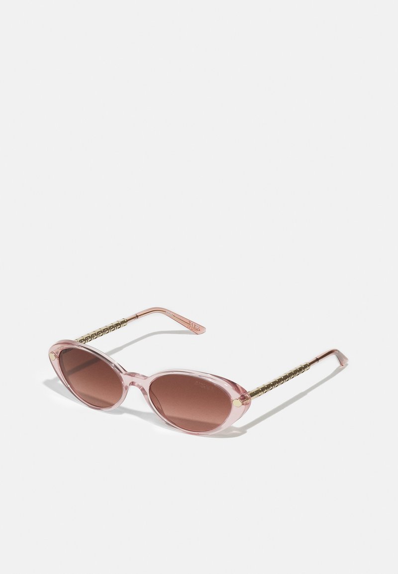 Rounded pink sunglasses with brown lenses. Transparent frame and gold-accented textured arms. Suitable for casual wear.