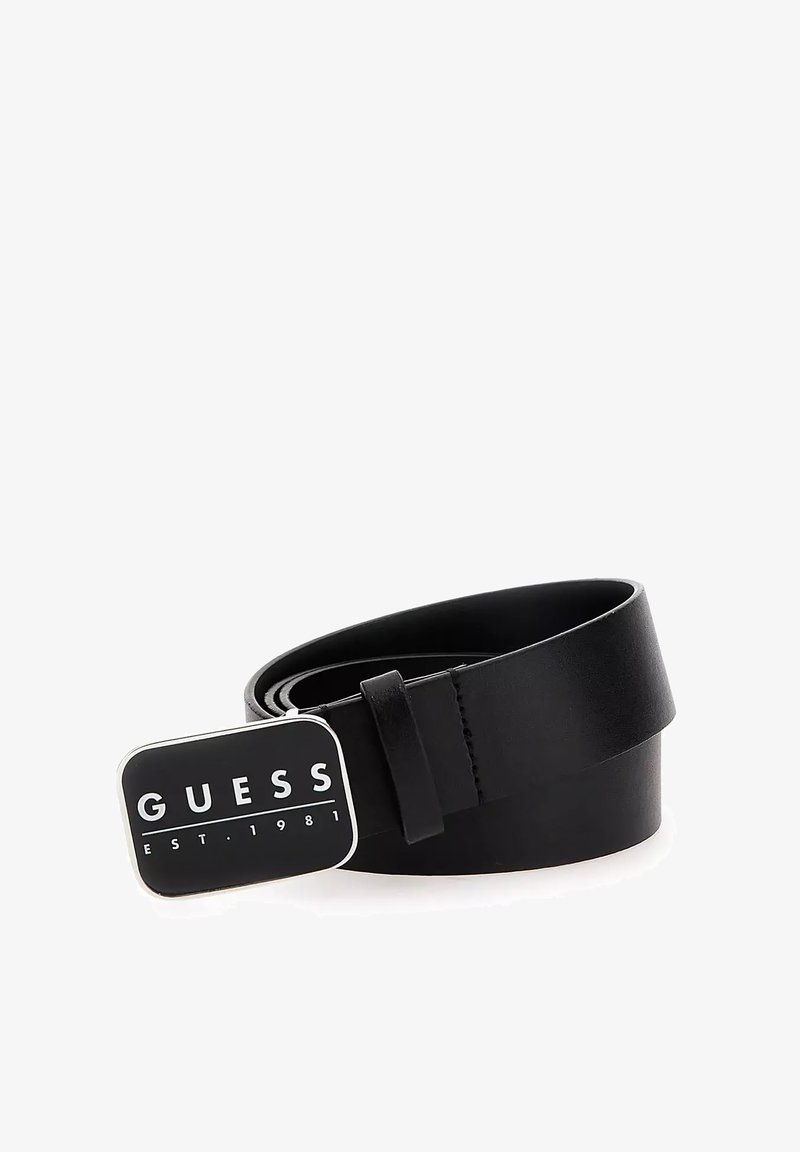 Cinturón de cuero negro con una hebilla rectangular plateada que presenta el logo "GUESS" y el texto "EST. 1981". Textura suave y diseño minimalista.