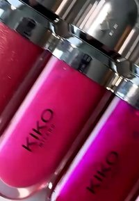 Trois tubes de gloss à lèvres KIKO Milano d'un rose vif avec des capsules argentées, étroitement disposés en angle.