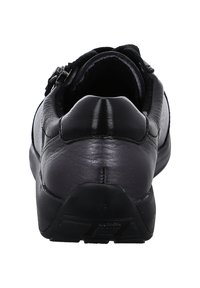 Chaussure en cuir noir avec un arrière arrondi, texture lisse et un design simple. Comprend un accent argenté près de l'ouverture de la chaussure.