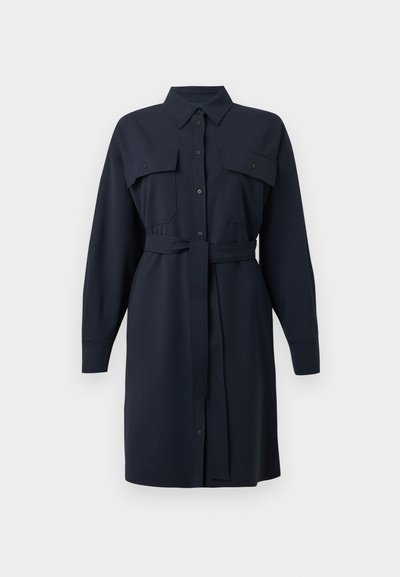 Ναυτικό μπλε φόρεμα με μακριά μανίκια, δύο τσέπες στο στήθος, κουμπιά μπροστά, γιακά και ζώνη που δένει στη μέση. Λείο ύφασμα με κομψή εφαρμογή.