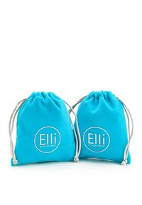 Kaks türkiissinist nöörikotti pehmest kangast. Igal koti peal on ümmargune valge logo tekstiga "Elli by Julie & Grace." Sujuv tekstuur.