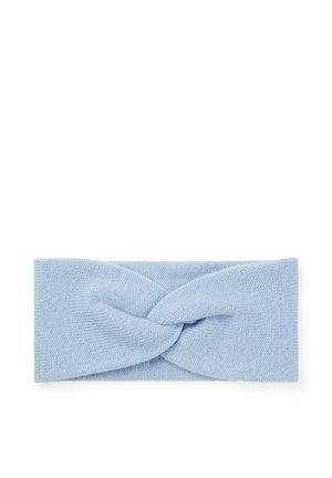 Lyseblåt strikket pandebånd med et snoet knudedesign i midten, lagt fladt på en hvid baggrund.