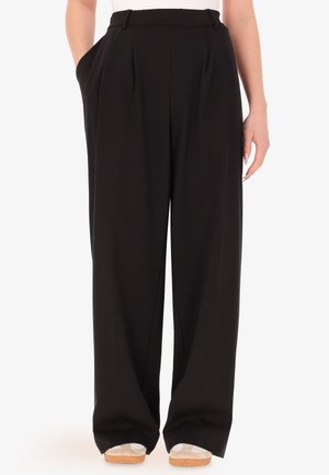 Pantaloni neri a gamba larga con pieghe frontali, tasche laterali e cintura strutturata, realizzati in un tessuto morbido e leggero.