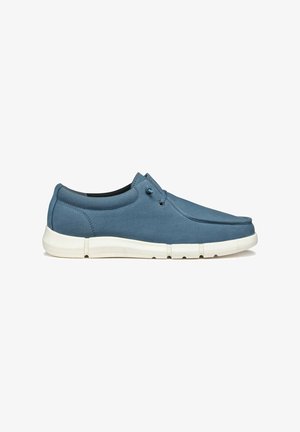 Scarpa slip-on in tela blu con suola bianca in gomma, dotata di punta piatta e occhielli minimi per i lacci, che offre una texture liscia e un design semplice.