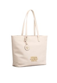Borsa tote beige con una superficie liscia, dotata di accessori in oro, un charm con logo e manici lunghi. Design minimalista con una forma strutturata.
