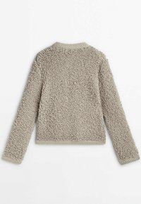 Veste en polaire beige duveteuse avec un col arrondi et des manches longues. Bord-côtes au niveau du col et des poignets ; tissu doux et texturé.