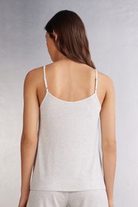 Světle šedá žebrovaná tílko s tenkými nastavitelnými ramínky, které se vyznačuje uvolněným střihem a měkkou texturou. Pohled ze zad zdůrazňuje hladké okraje.