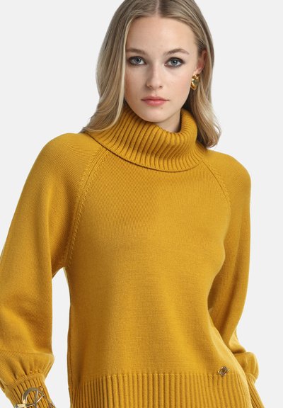 Mustard yellow turtleneck sweater with ribbed collar and hem. Features balloon sleeves with gathered cuffs and small logo accent at the bottom.